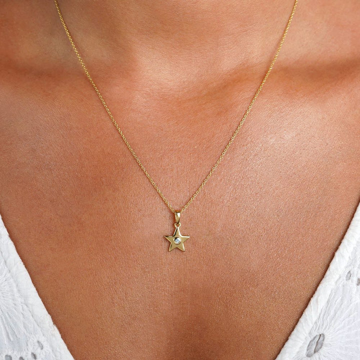 Gold necklace with a star and a Blue Topaz crystal. Beautiful star necklace in gold and with a small crystal of Blue Topaz.
