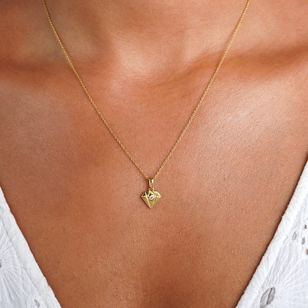Gold necklace with a diamond design and a Clear Quartz crystal in it. Beautiful gemstone necklace with a golden diamond pendant and a Clear Quarts gemstone in it. 