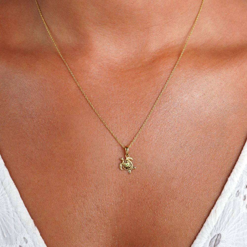Gold turtle necklace with a small green Peridot crystal. Gemstone necklace in gold with a cute turtle and a tiny green gemstone Peridot.