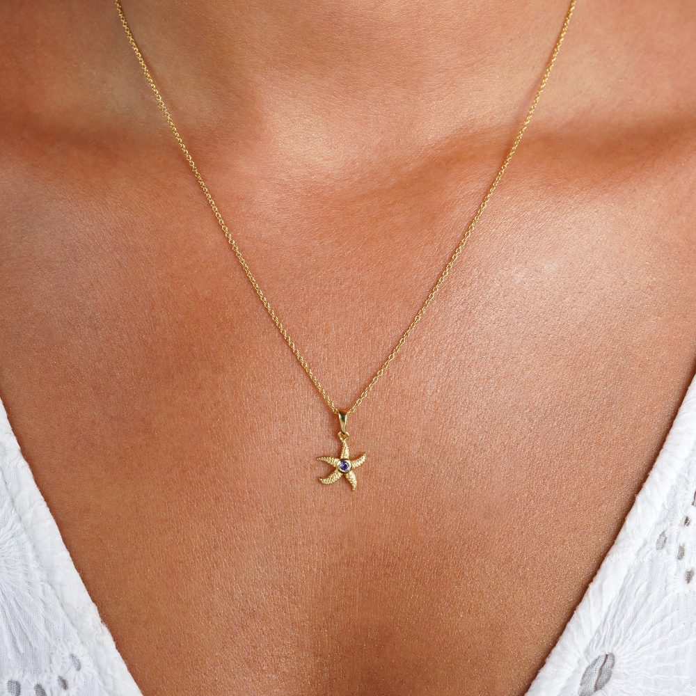 Starfish necklace in gold and with the birthstone of September Iolite. Gold necklace with a star fish and Iolite gemstone.