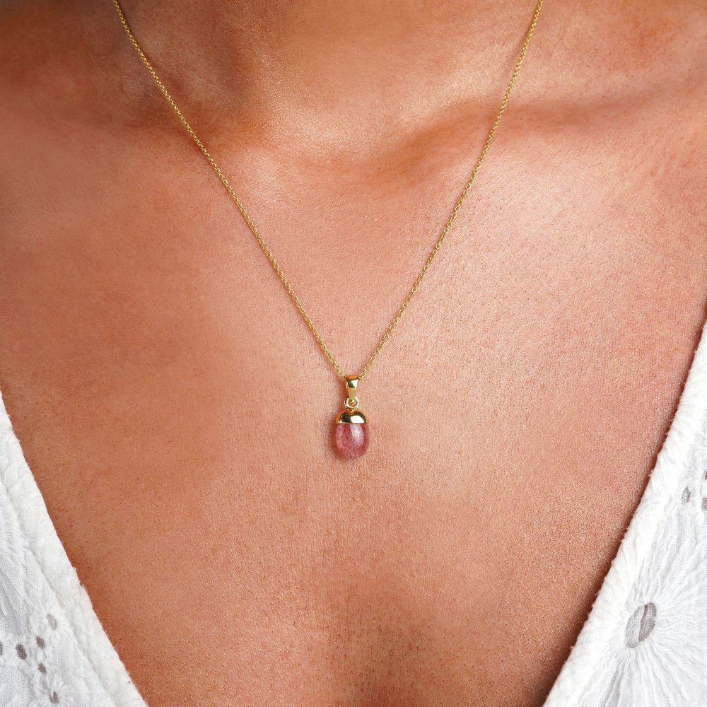 Tumbled strawberry quartz crystal in gold to wear in a necklace. Jewelry with the Strawberry Quartz crystal has a red rose color.