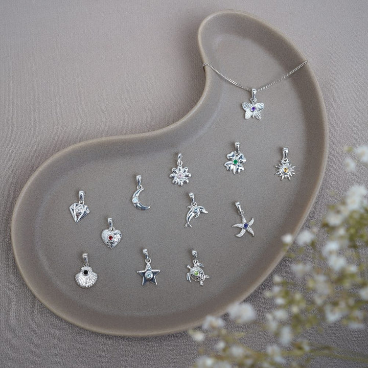 Silver charms with all the birthstones of the year. Jewelry with birthstones in cute symbols.