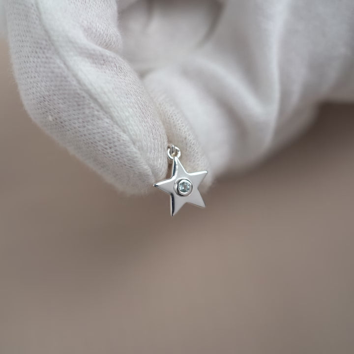 Gemstone charm with a star and the birthstone of December Blue Topaz. Crystal charm to wear in a necklace with a cute silver star and the gemstone Blue Topaz.