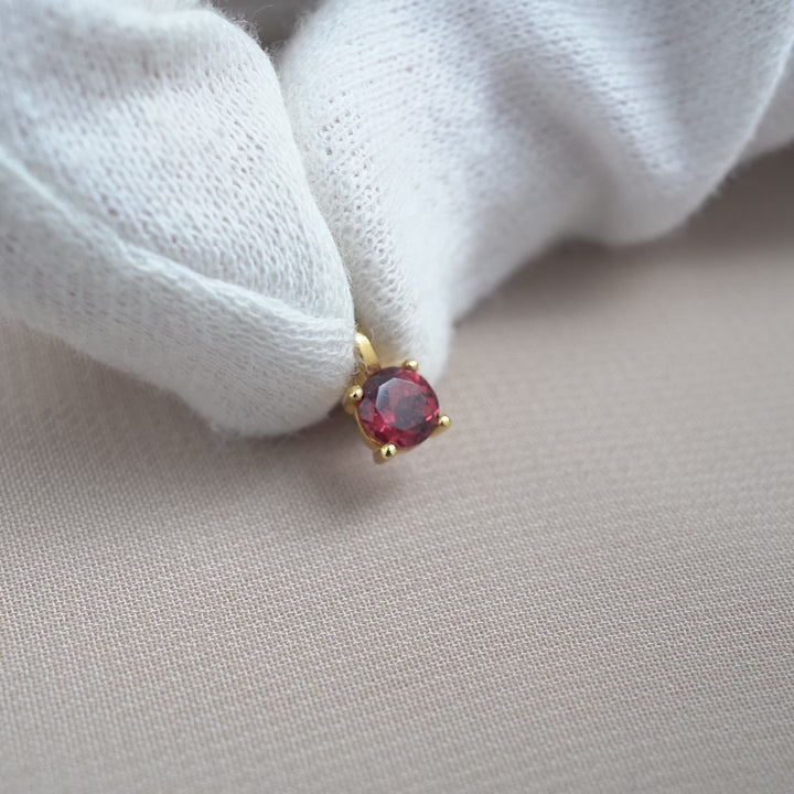 Classy crystal charm with red gemstone Garnet in gold. Crystal charm with Garnet in a classic design.