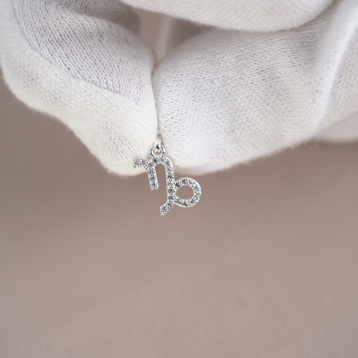 Silver charm with Capricorn (Goat) symbol in silver. Gemstone charm with zodiac sign Capricorn (Goat) with White Topaz crystals.