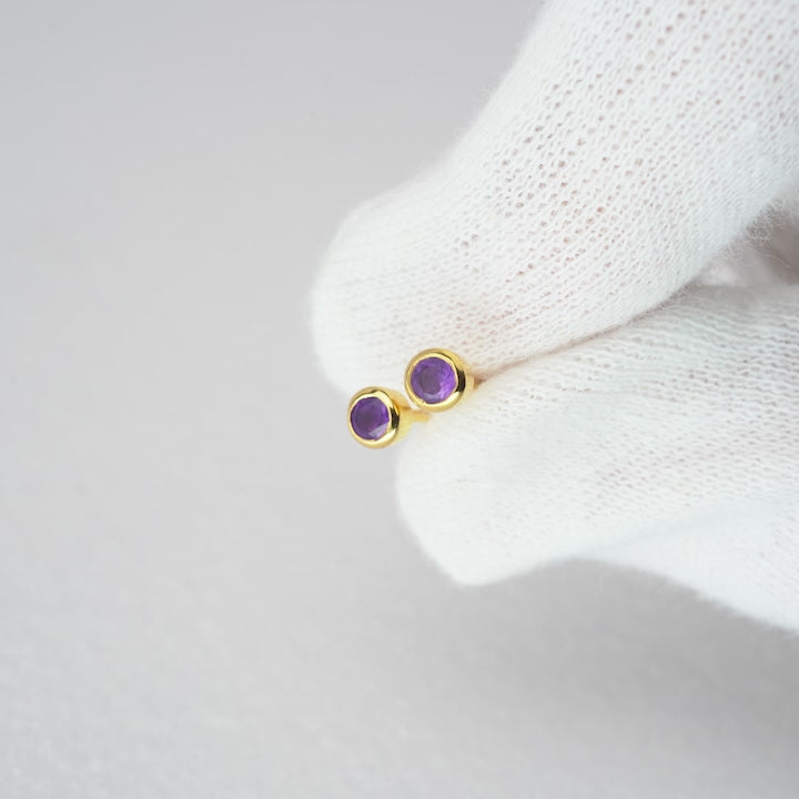 Stud earrings in gold with gemstone Amethyst. Crystal earrings with purple gemstone Amethyst in gold.
