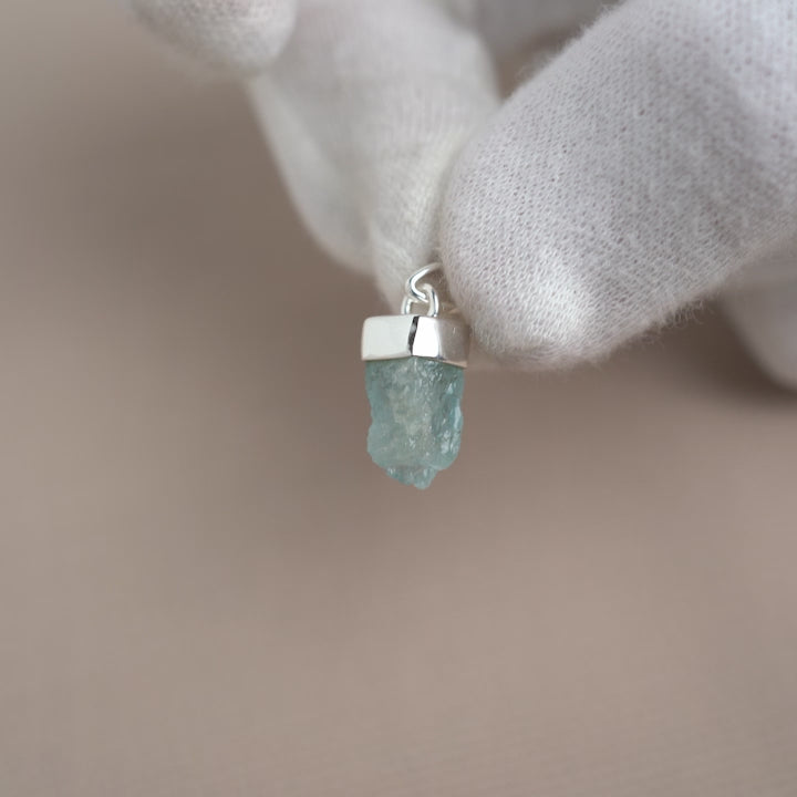Blue Aquamarine gemstone jewelry pendant in silver. Gemstone charm with raw Aquamarine crystal in silver.