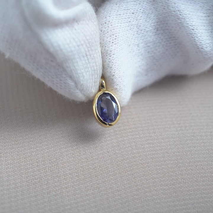 Crystal charm with Iolite in a classy design. Beautiful gemstone pendant with a purle, blue gemstone Iolite in gold.