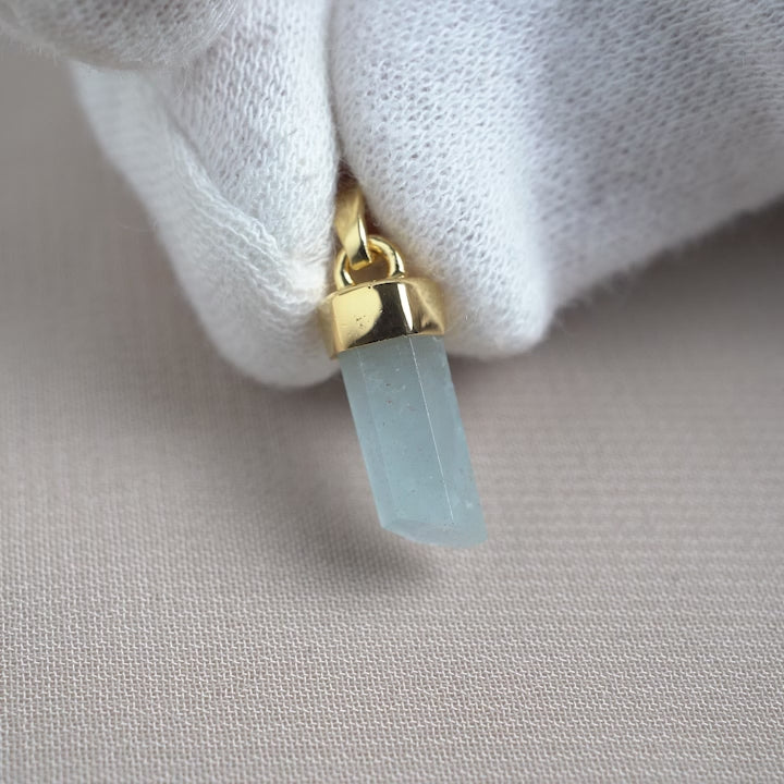 Aquamarine pendant shaped as a natural point with gold details. Gemsotne pendant with Aquamarine in a modern design.