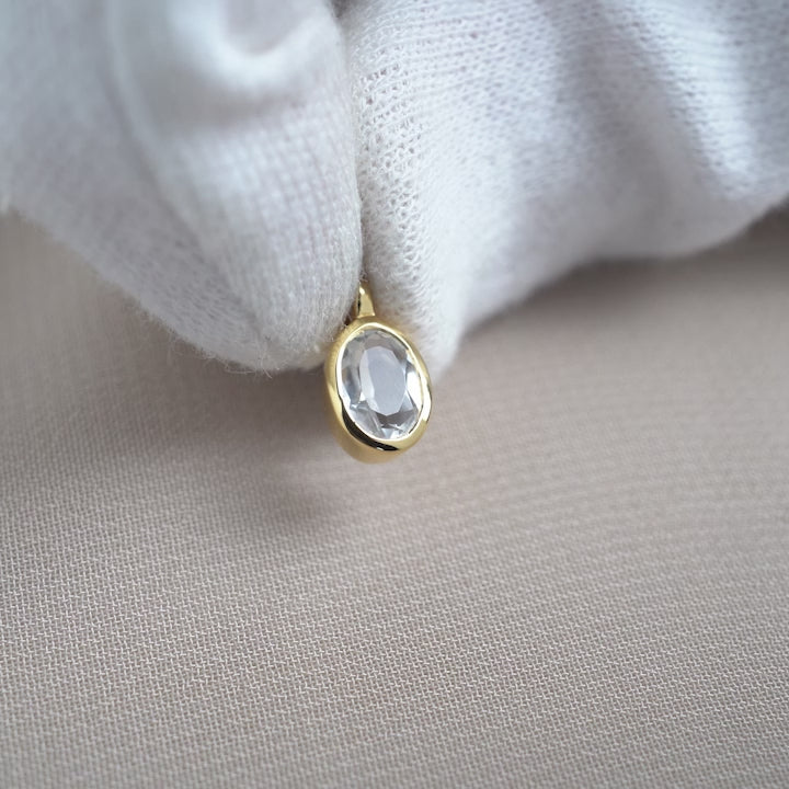 Gold charm with Clear Quartz in a classy design. Clear Quartz jewelry in gold to wear with a necklace.