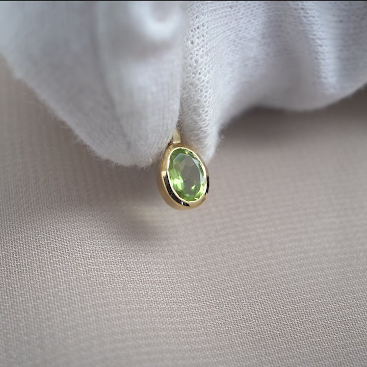Peridot gemstone charm in gold. Crystal jewelry with the birthstone of August in gold.