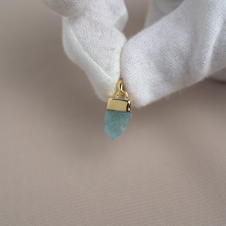 Raw blue Aquamarine crystal pendant. A blue raw gemstone charm with Aquamarine in gold.