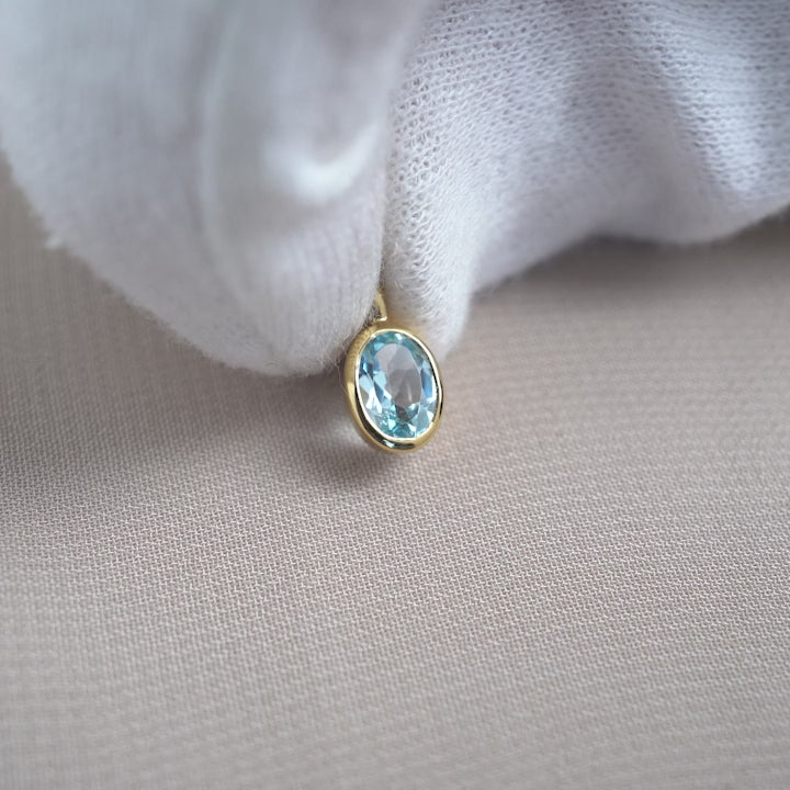 Gold charm with December birthstone Blue Topaz. Gemstone jewelry with Blue Topaz in gold for necklace.