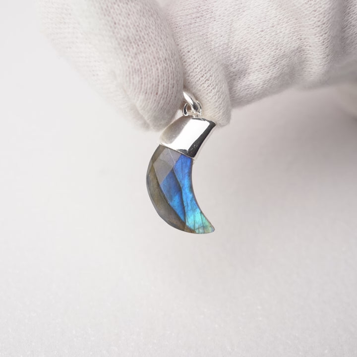 Gemstone pendant with moon shaped Labradorite crystal with silver details. Crystal jewelry pendant with Labradorite shaped into a moon.