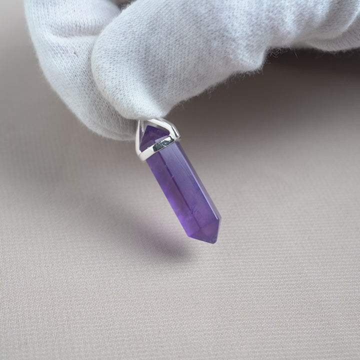 Amethyst point pendant with silver details. Amethyst jewelry with a point design.