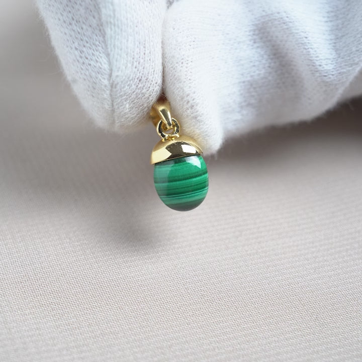 Malachite pendant in a tumbled gemstone design with gold details. Pendant with Malachite crystal with a green pattern.