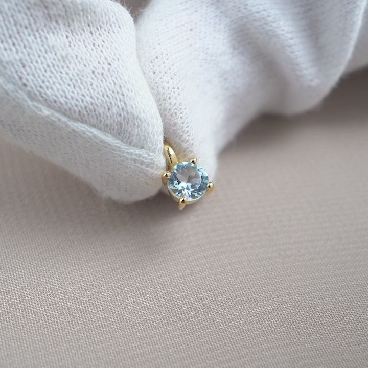 Blue Topaz crystal charm in gold. Gemstone charm with sparkly Blue Topaz crystal with gold details.