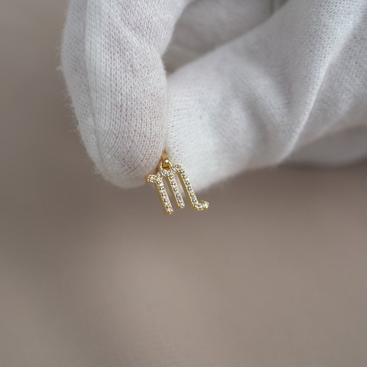 Gold charm with Scorpio sign and White Topaz crystals.