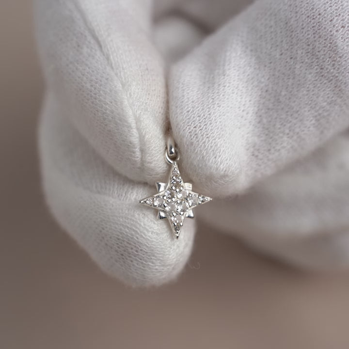 Silver charm with a star filled with White Topaz gemstones.