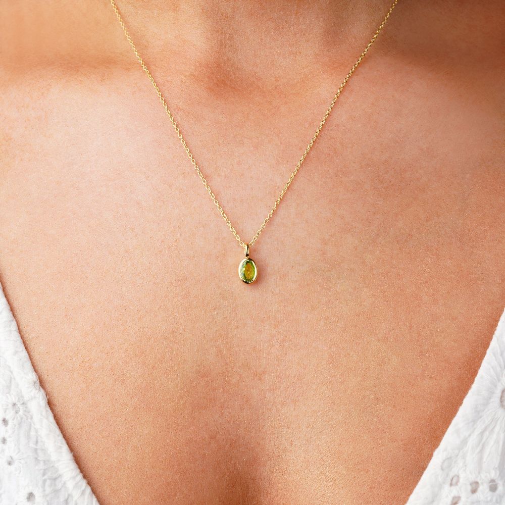 Necklace with green Peridot crystal which is the birthstone for August. Jewelry with green gemstone Peridot in gold to wear as a necklace.