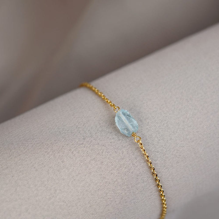 Bracelet in gold with a raw Aquamarine crystal. Blue raw gemstone bracelet in gold.