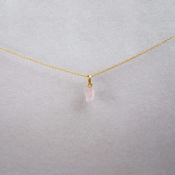 Rose Quartz in raw form charm in gold. Petite and neat gemstone necklace with raw Rose quartz in gold.