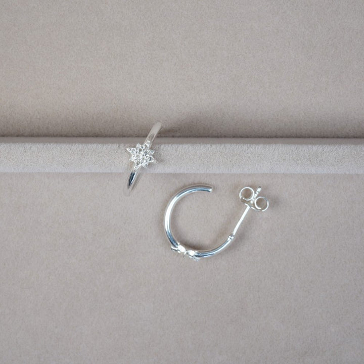 Hoops earrings in silver with sparkling star of White topaz crystals. Silver earrings with star and gemstones.