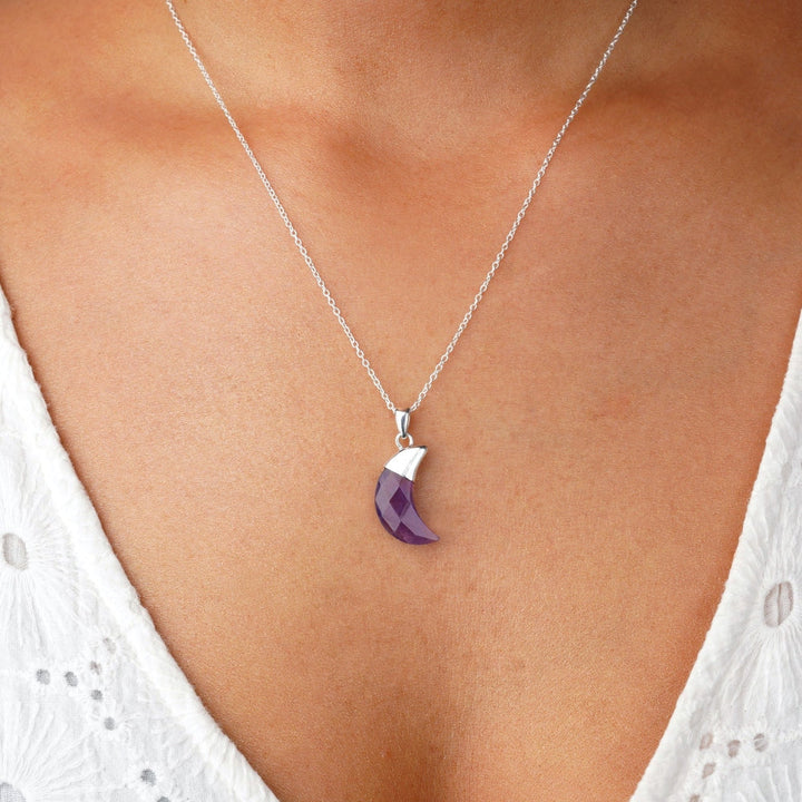Crystal necklace with purple Amethyst in the shape of the moon. Modern gemstone jewelry with purple Amethyst to wear in a necklace with silver details.