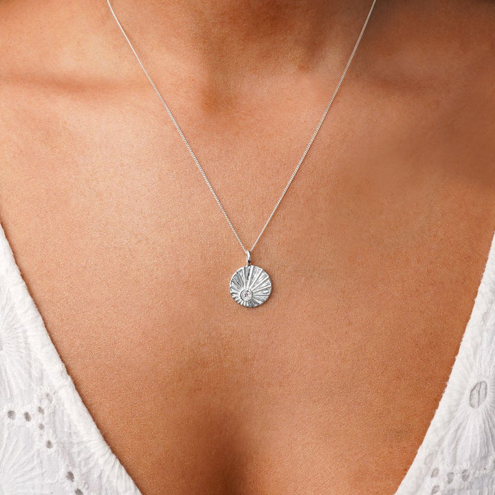 Coin necklace with crystal Clear Quartz in silver. Clear Quartz necklace in coin with sunrise motif.