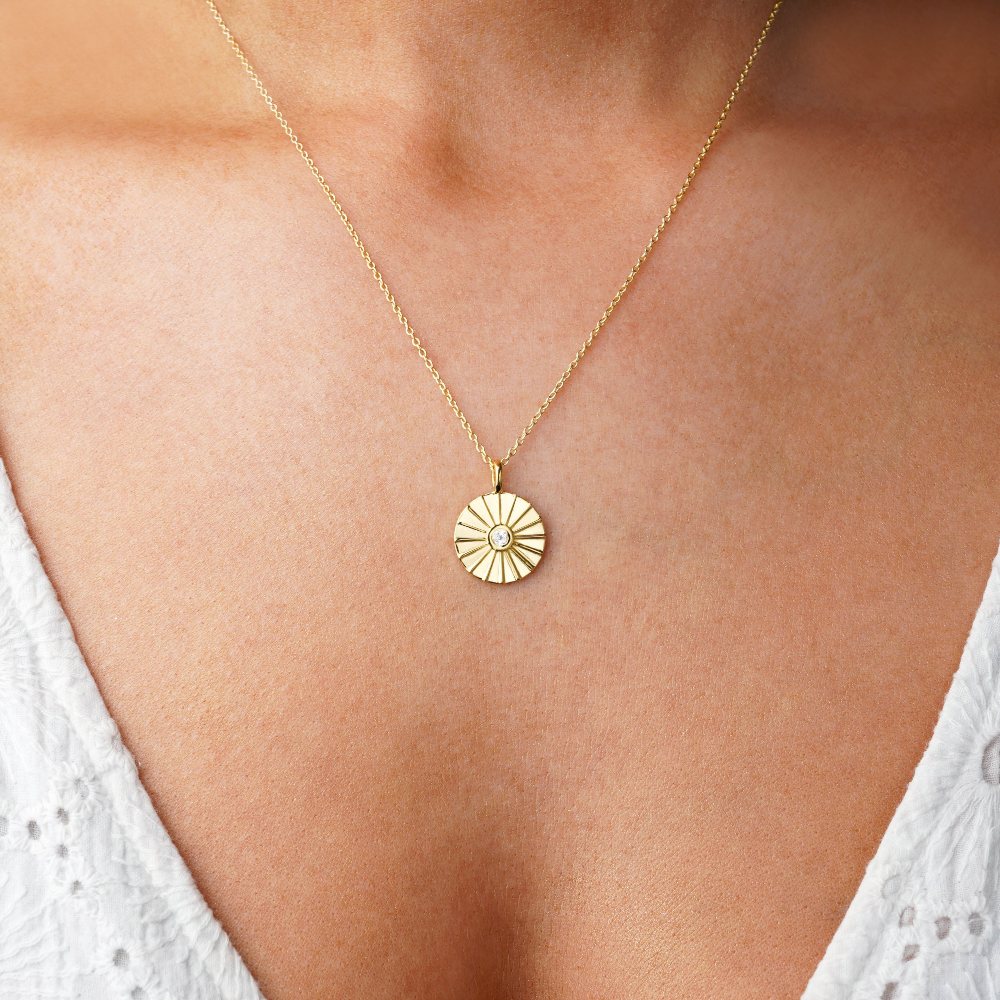 Coin necklace in gold with white topaz. Sun necklace in gold with crystal white topaz which is April's birthstone.