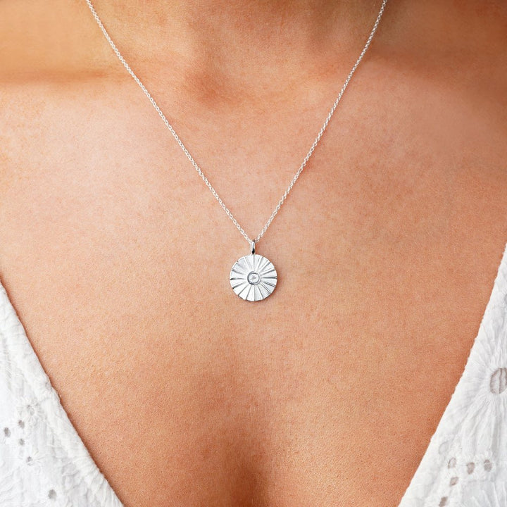 Sun necklace in silver with gemstone white topaz which is April's birthstone. Crystal necklace with white topaz in a sun.