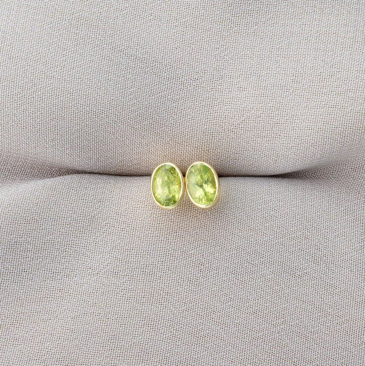 Earrings in gold with green crystal Peridot. Gemstone earrings with August's birthstone Peridot.