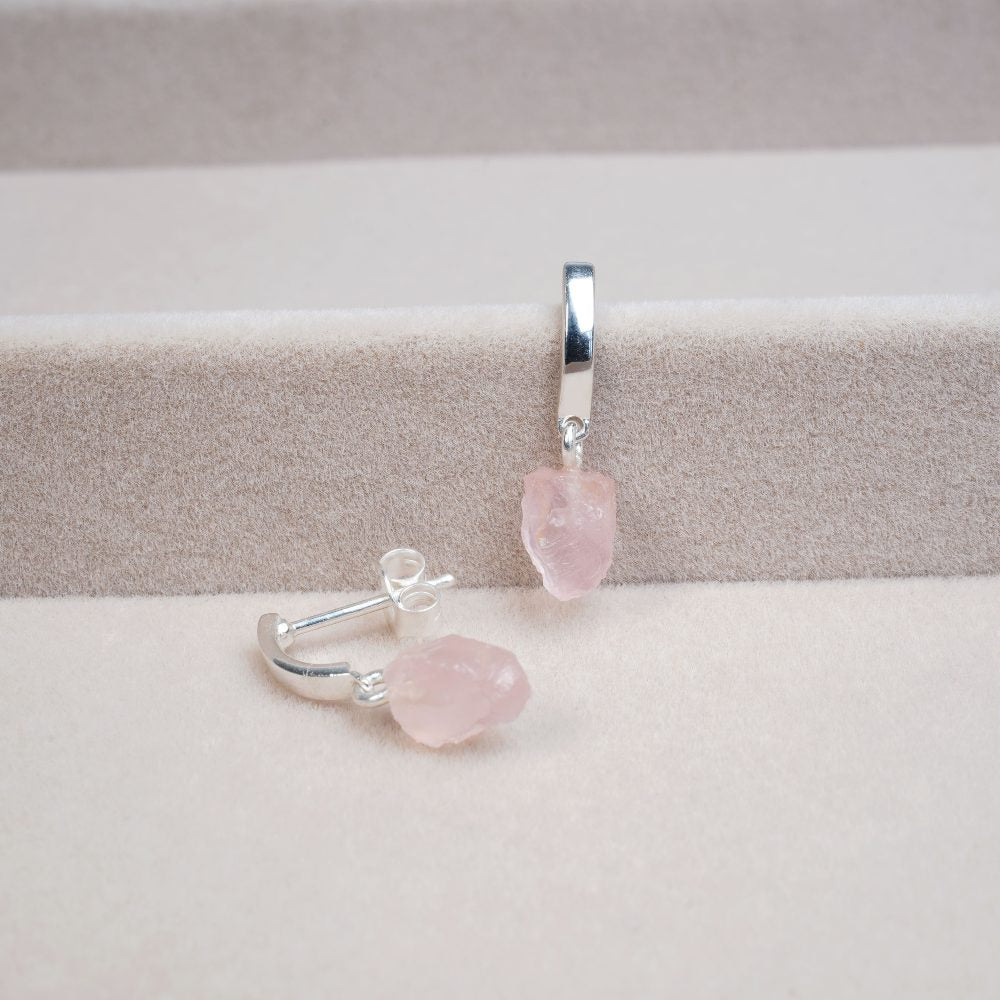 Modern earrings in silver and with small pink raw crystal. Rose quartz earrings in silver and cute design.