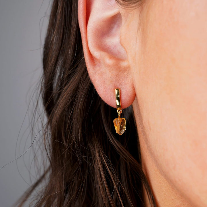 Gold earrings with raw crystal Citrine, which is November's birthstone. Citrine earrings in gold in a modern design.