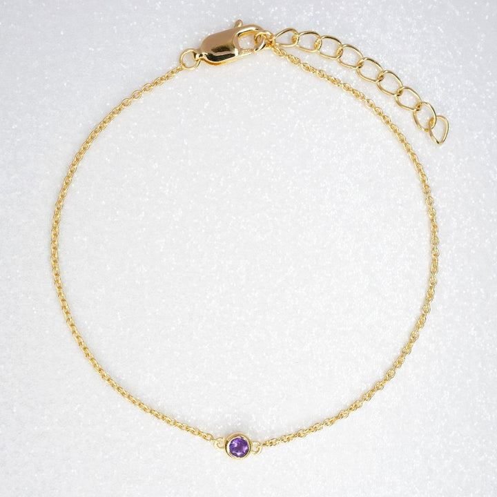 Gold bracelet with purple Amethyst which is February's birthstone. Jewelery with Amethyst crystal to wear as a bracelet in gold.