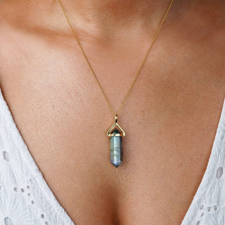 Necklace with Labradorite point shaped. Point in crystal Labradorite with gold hanging on a gold chain. Gemstone jewelry with crystal Labradorite that shimmers in different colors.