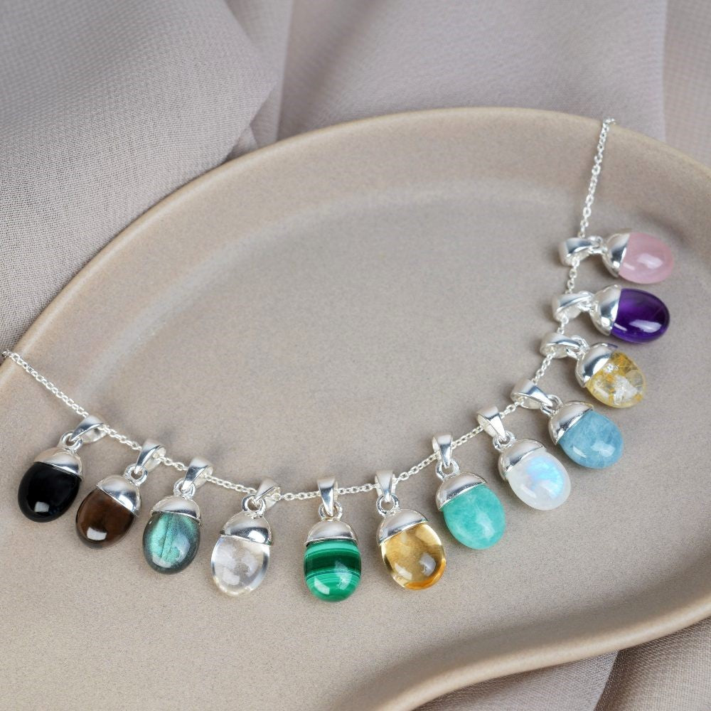 Tumbled gemstone charms in silver. Beautiful crystal jewelry with colorful gemstones.